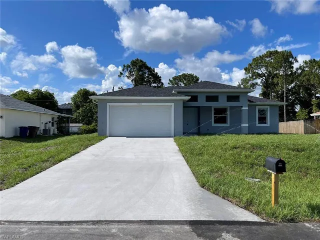 View of front of home with a front lawn and a garage