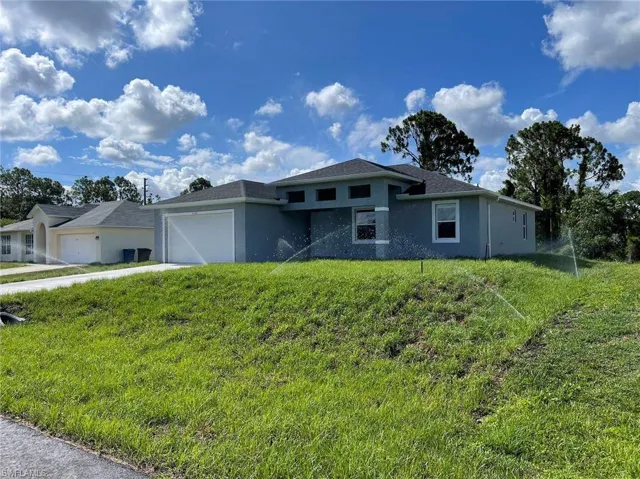 View of front of home with a garage and a front lawn