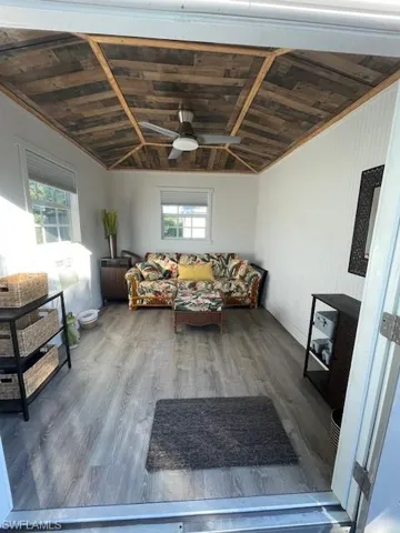 Living room featuring a wealth of natural light, wood ceiling, lofted ceiling, and wood-type flooring