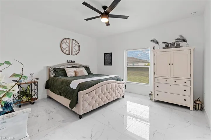 Bedroom with light marble finish flooring and a ceiling fan