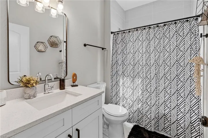 Full bath with vanity and a shower with shower curtain