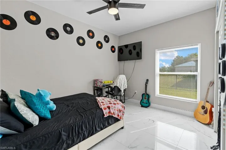 Bedroom featuring marble look tile flooring and a ceiling fan