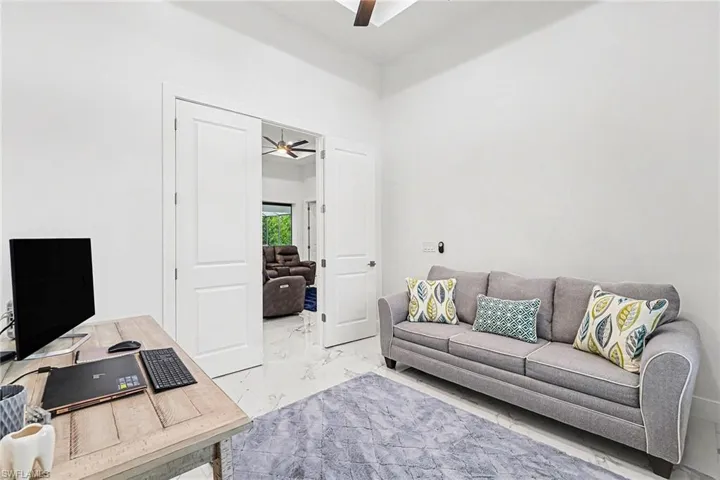 Office featuring ceiling fan and light marble finish flooring