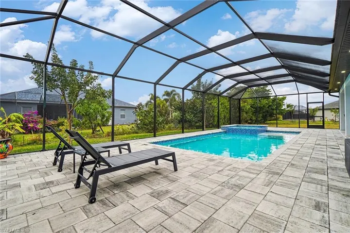 Combined pool / hot tub featuring a sunroom, a lanai, and a patio