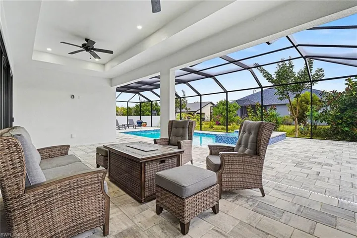 View of patio featuring a sunroom, an outdoor living space, ceiling fan, an outdoor pool, and a lanai
