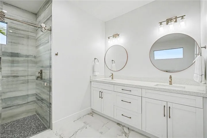 Bathroom with double vanity and a stall shower