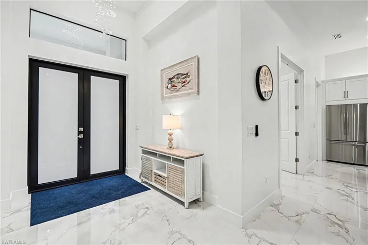 Entryway featuring light marble finish floors and french doors