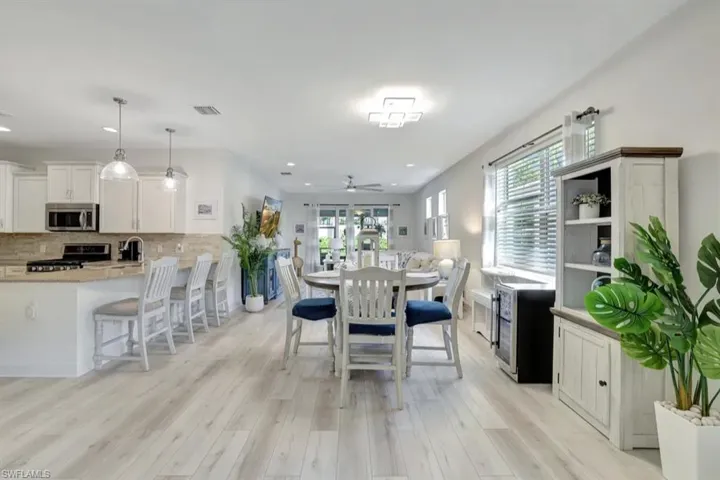 Dining area featuring light wood-type flooring, ceiling fan, and recessed lighting