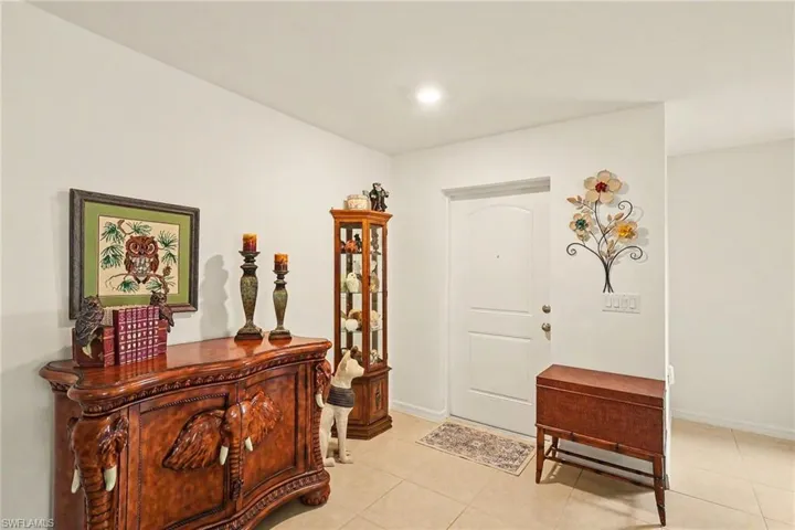 Tiled entry featuring a paneled door, recessed lighting, and light-toned walls