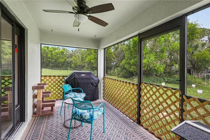 Screened lanai featuring a ceiling fan, sliding glass door access, and wood-finish lattice accent panels