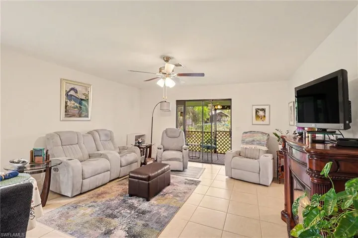 Living area featuring light-toned tile flooring and a ceiling fan