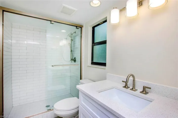 Bathroom with walk in shower, vanity, and toilet