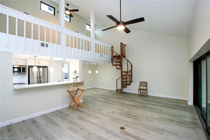 Unfurnished living room featuring high vaulted ceiling, ceiling fan, and light hardwood / wood-style flooring