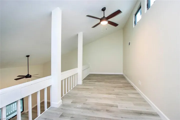 Hall featuring high vaulted ceiling and light wood-type flooring