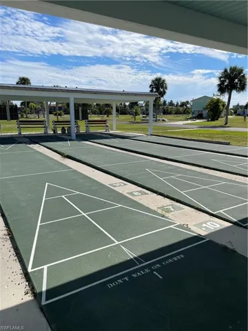 Surrounding community featuring shuffleboard and a yard