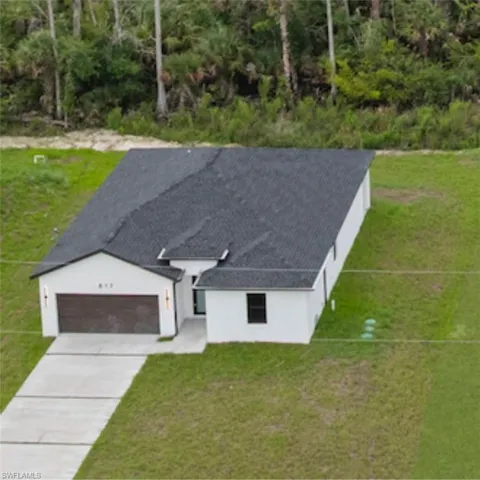 Single story home featuring driveway, stucco siding, an attached garage, and a front yard