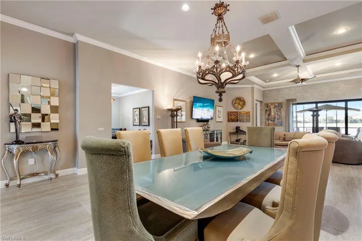 Dining room with baseboards, coffered ceiling, visible vents, and crown molding