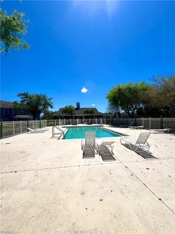 Pool with a patio area and fence