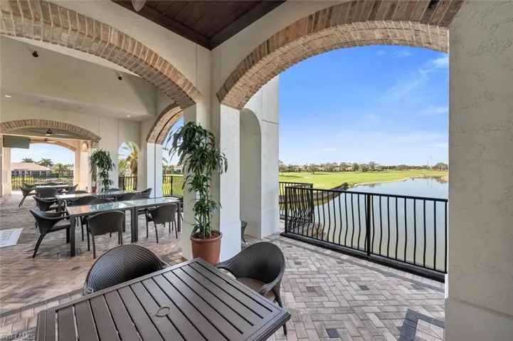 View of patio / terrace with outdoor dining area, view of golf course, a water view, and a ceiling fan