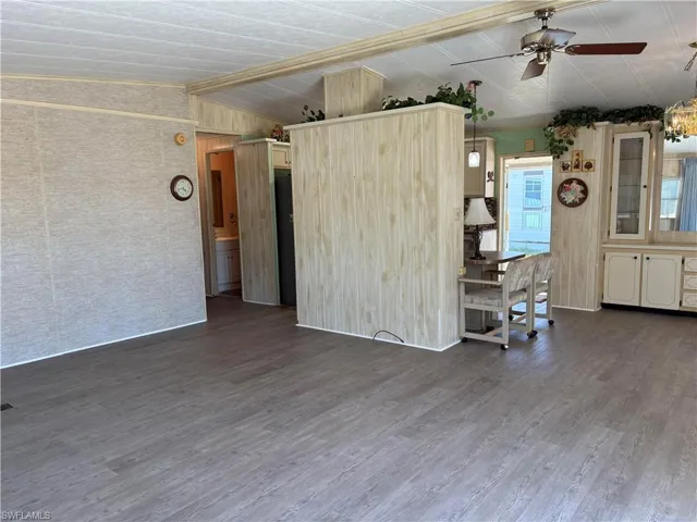 Unfurnished living room featuring lofted ceiling, wood finished floors, and a ceiling fan