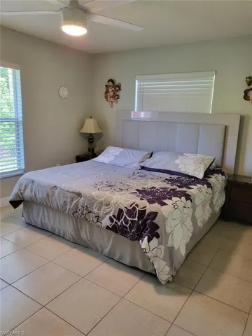Bedroom featuring light tile patterned floors and ceiling fan