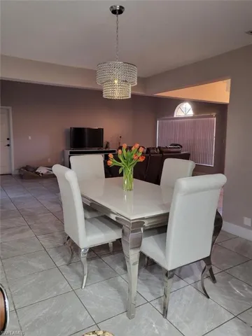 Tiled dining area featuring an inviting chandelier