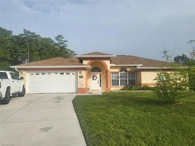 View of front of house featuring a garage and a front yard