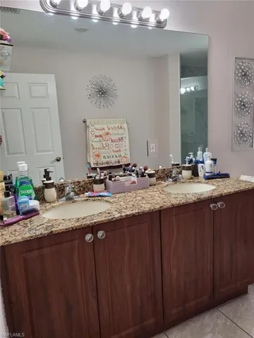 Bathroom featuring tile patterned flooring and double sink vanity