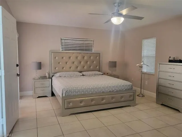 Bedroom with light tile patterned floors and ceiling fan