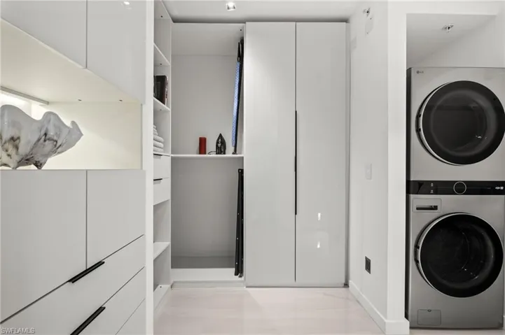 Integrated laundry area featuring a stacked washer and dryer