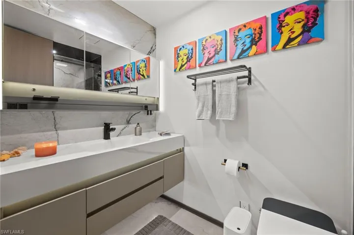 Modern bathroom vanity with integrated sink, matte black faucet, and under-cabinet lighting