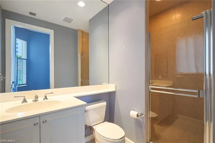 Bathroom featuring vanity, toilet, and a shower with shower door