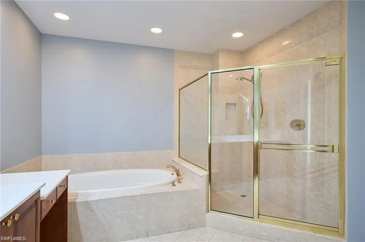 Bathroom with plus walk in shower, vanity, and tile patterned floors