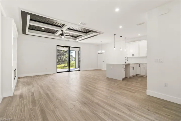 Unfurnished living room with a chandelier, recessed lighting, light wood-type flooring, and a ceiling fan