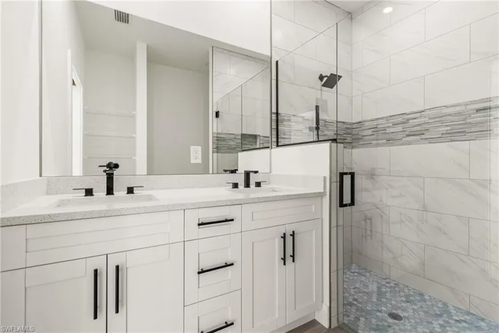 Full bathroom with a shower stall and double vanity