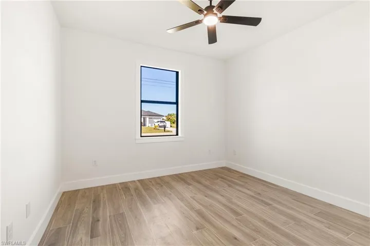 Empty room featuring light wood finished floors and a ceiling fan
