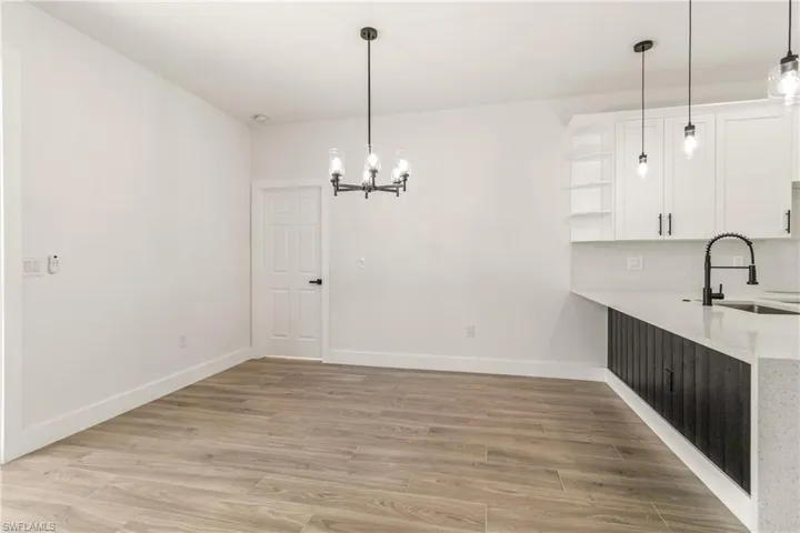 Unfurnished dining area with light wood-type flooring and a chandelier