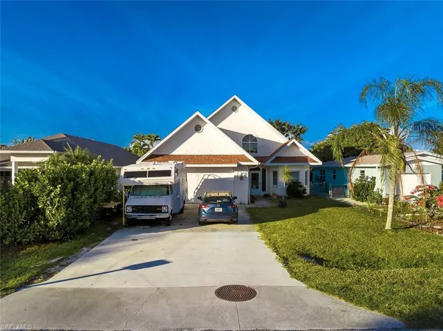 View of front of house with concrete driveway and a front yard