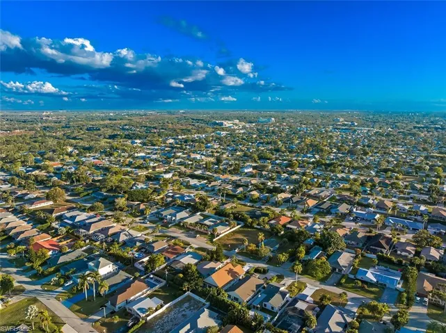 Aerial view of property and surrounding area featuring nearby suburban area