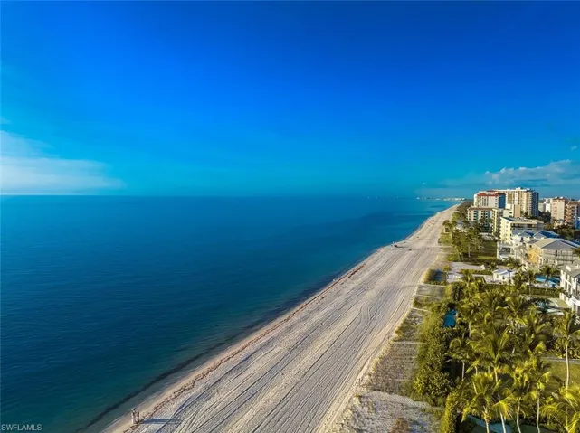 Aerial view of property and surrounding area featuring expansive coastline