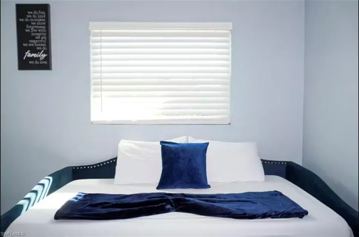 Bright room featuring a window with horizontal blinds, offering natural light