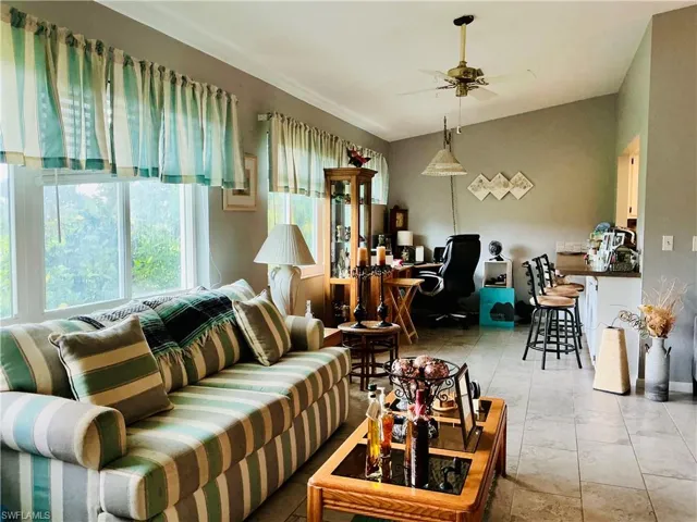 Living area featuring ceiling fan and tile patterned flooring