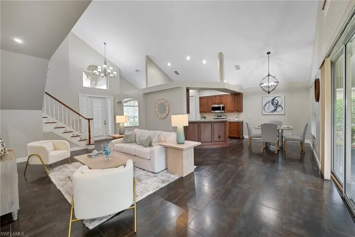 Living room with hanging lights, vaulted ceiling, and arched walkways