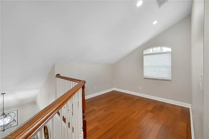 Additional living space with lofted ceiling, dark wood-style flooring, and recessed lighting