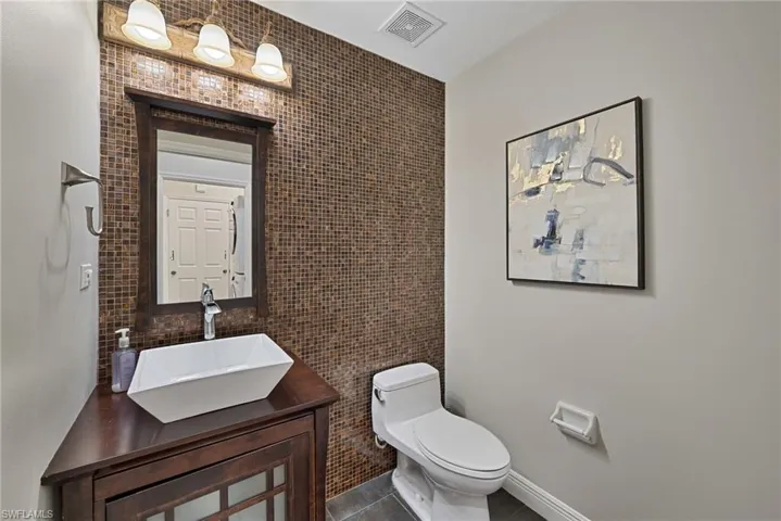 Powder Bathroom featuring tile walls and vanity