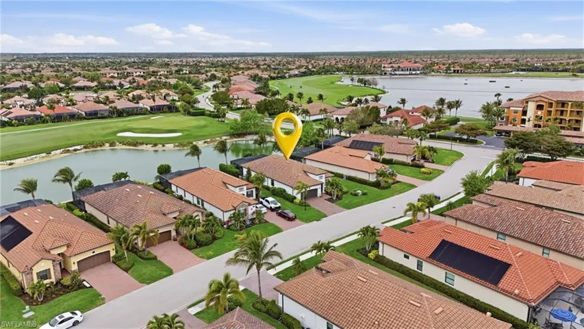 Aerial view of residential area with a large body of water and a golf club