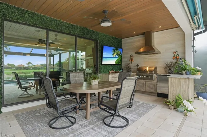 View of patio with an outdoor kitchen / dining area, ceiling fan, and a residential view