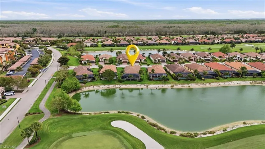 Aerial view of residential area featuring a local golf course and a nearby body of water