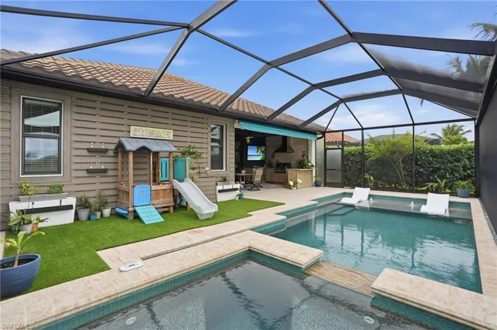 Combined pool / hot tub with a lanai, a sunroom, a patio, and a yard