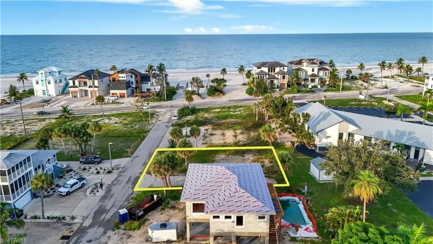 Aerial view of residential area featuring extended coastline and property boundaries highlighted - Virtually Edited Image